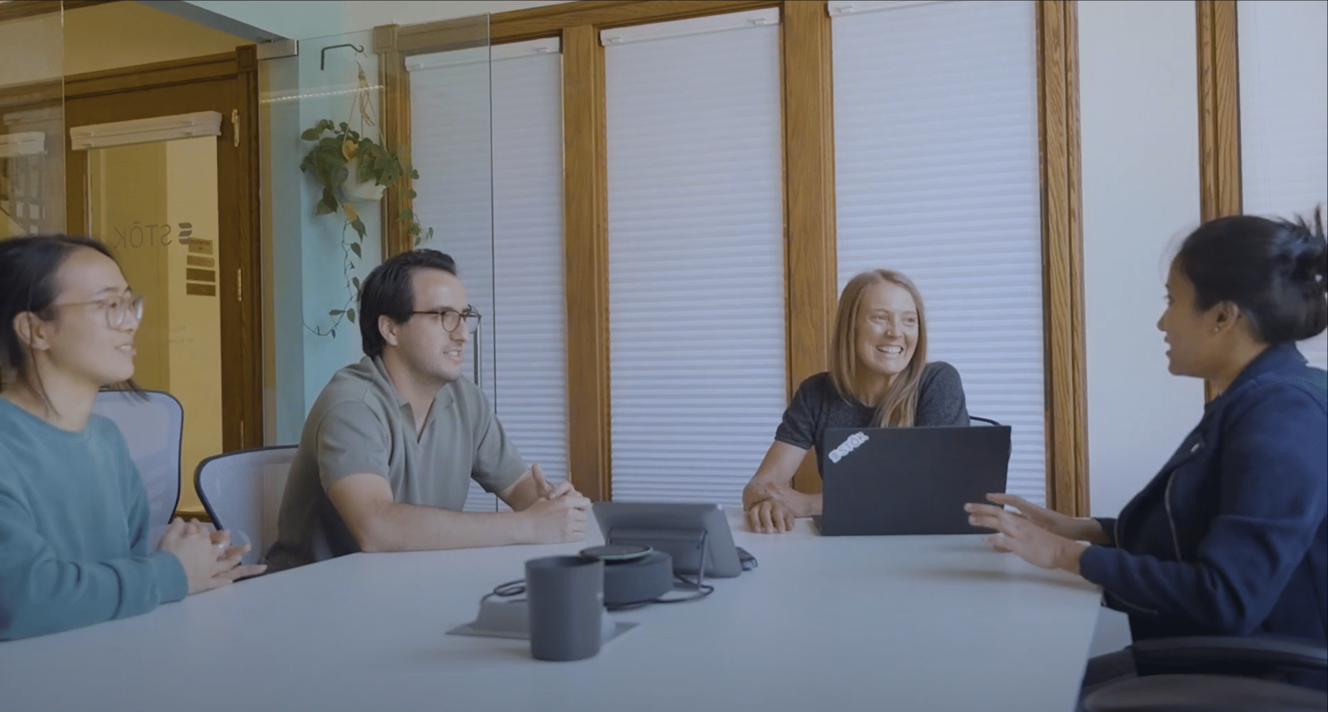 4 people sitting at a table and discussing a topic